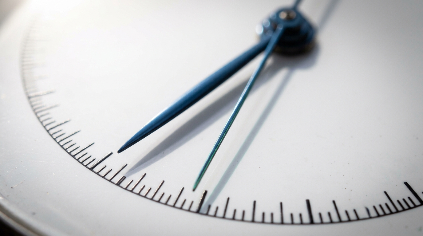 An extreme close-up of a chronograph dial showing the split hand and the main sweep hand casting two separate, diverging shadows across the engraved tick marks